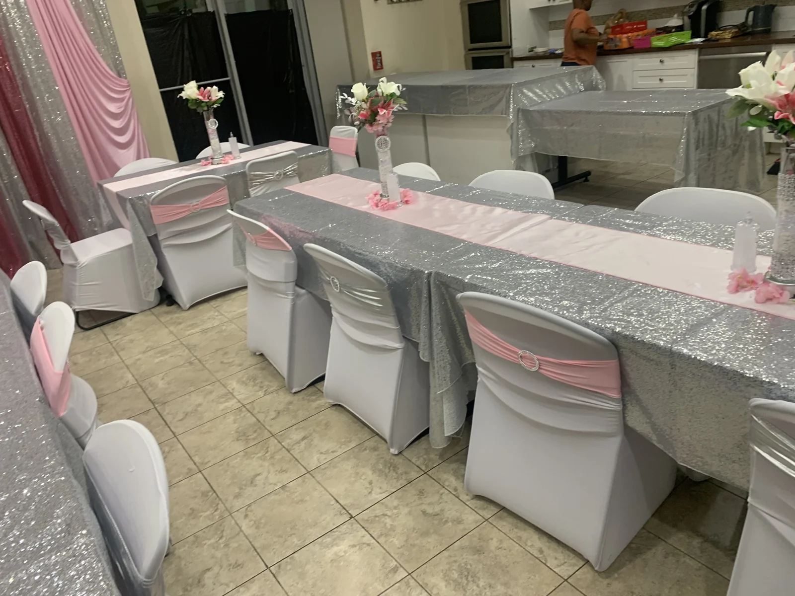 Angled view of coordinated pink-and-silver tablescapes and draping
